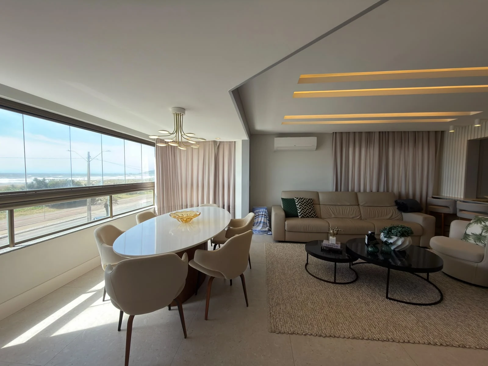 Sala e mesa de jantar do apartamento, com vista real para o mar em Mar Grosso